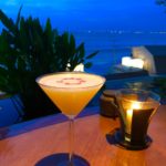 orange liquid in clear martini glass on brown wooden surface